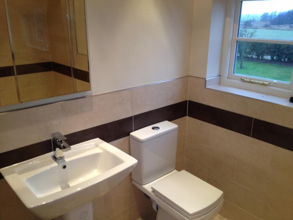 Bathroom with pedestal basin, close-coupled toilet and border tiles