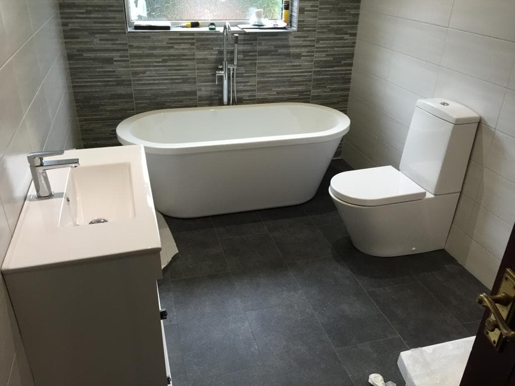 Bathroom with freestanding bath, vanity basin and close-coupled toilet